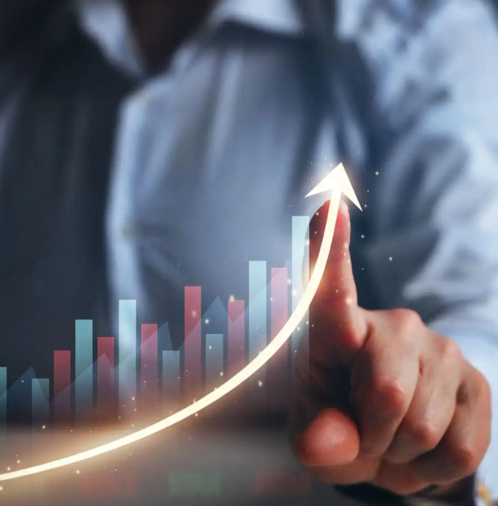 A person using their finger to draw an upward arching arrow through a bar chart.